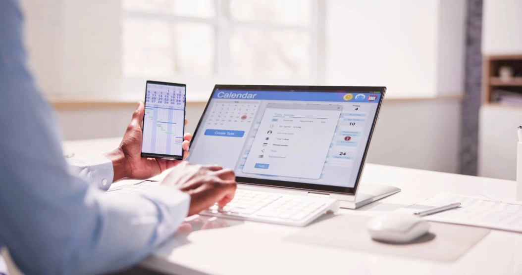 An employee enters their time tracking information into a PC.